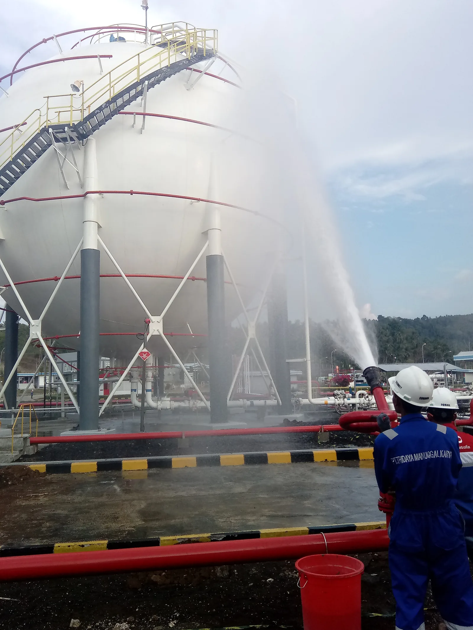 Fire monitor discharging over a storage tank during commissioning at AMRG